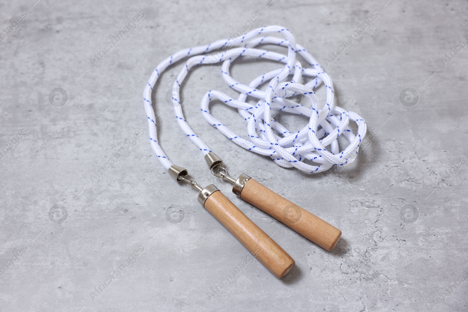 Photo of Skipping rope on grey table. Sports equipment