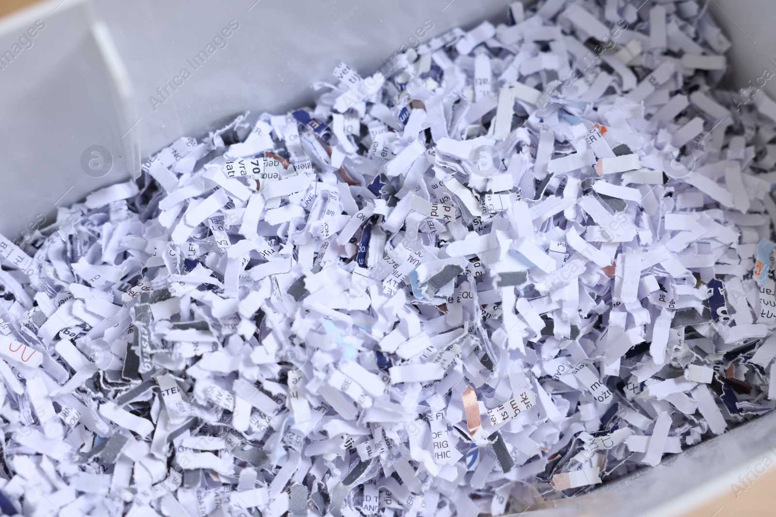 Photo of Shredded paper strips in bin, closeup view