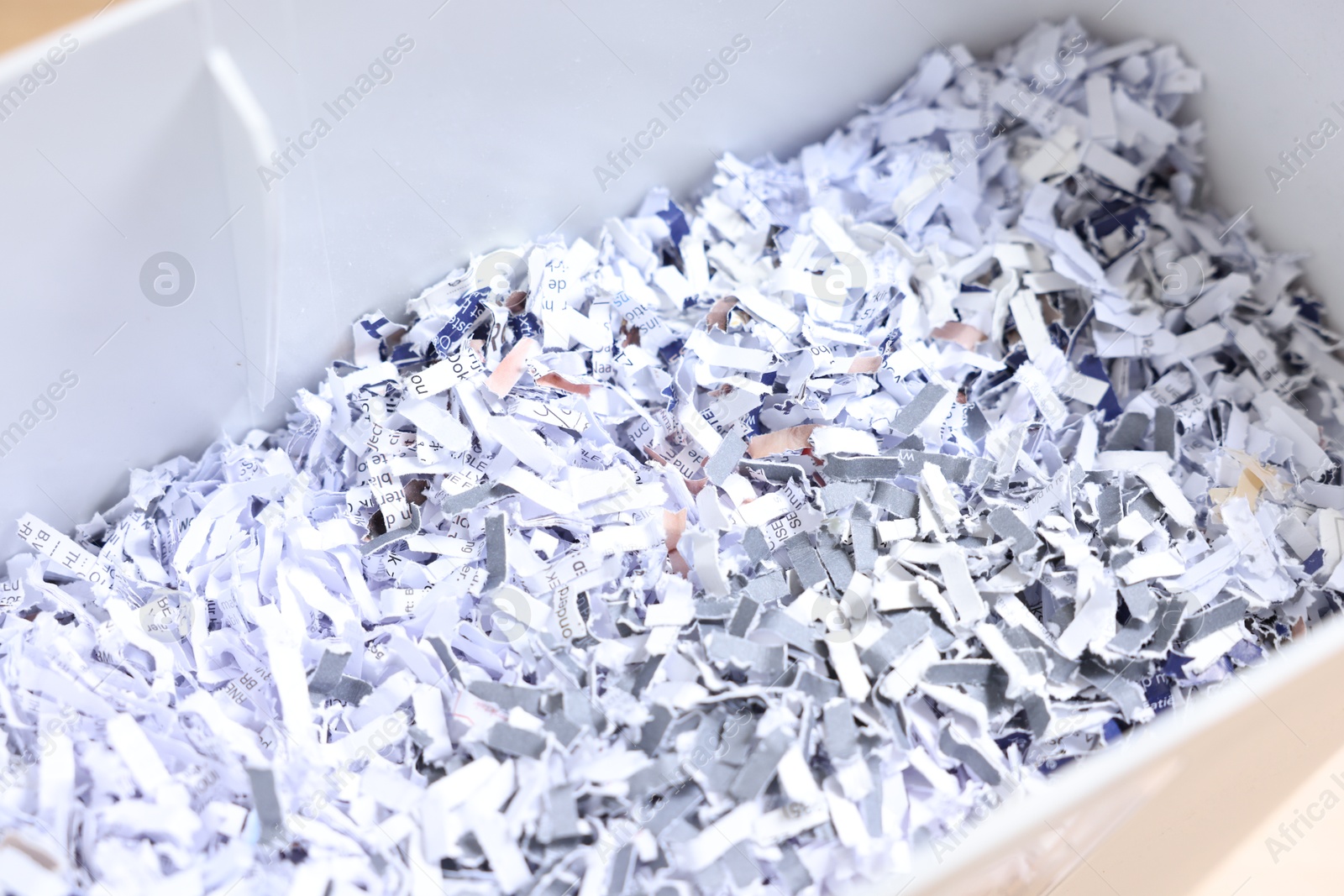 Photo of Shredded paper strips in bin, closeup view