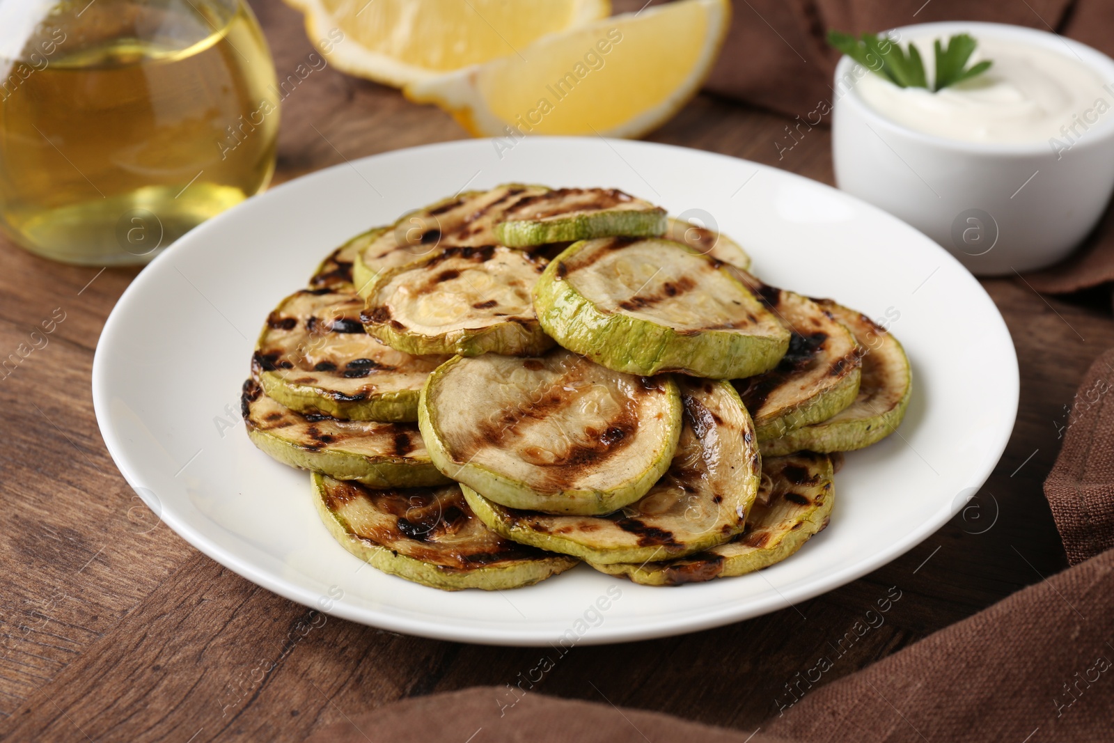 Photo of Tasty grilled courgette slices on wooden table