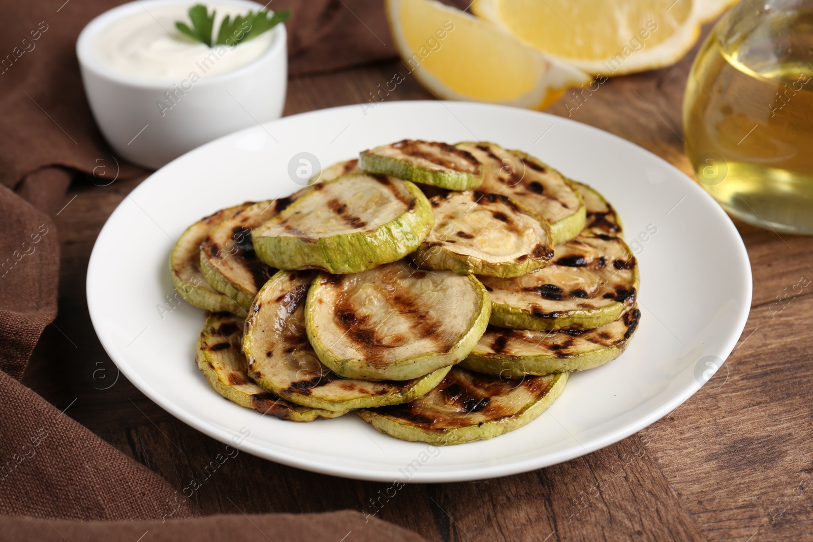 Photo of Tasty grilled courgette slices on wooden table