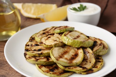 Tasty grilled courgette slices on table, closeup