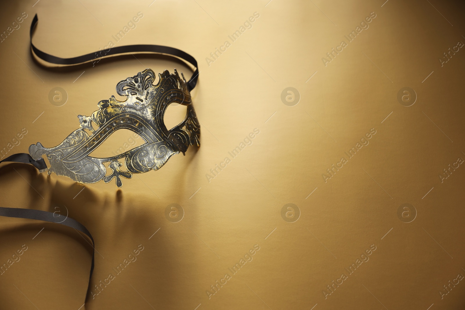 Photo of Elegant face mask on beige background, space for text. Theatrical performance