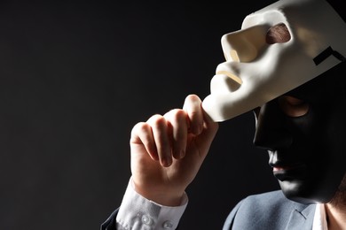 Theatrical performance. Man with plastic masks on black background, space for text