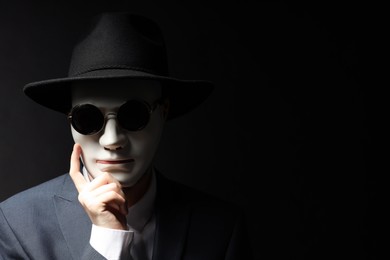 Theatrical performance. Man with plastic mask and sunglasses on black background, space for text