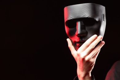 Theatrical performance. Man with plastic mask on dark background, closeup. Space for text