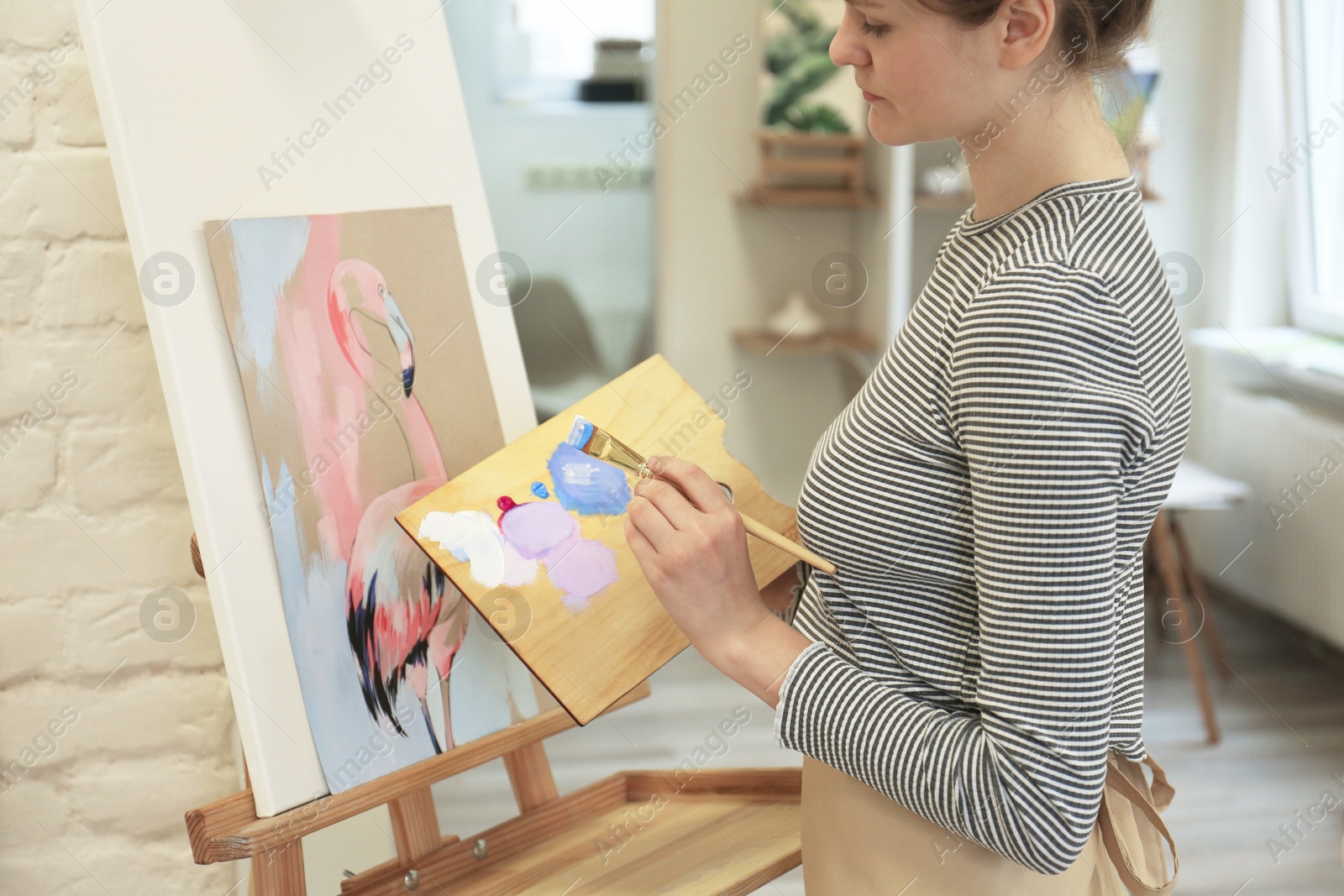 Photo of Woman drawing picture with brush in studio, closeup