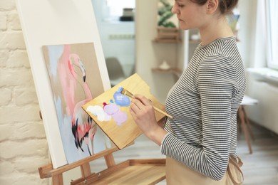 Woman drawing picture with brush in studio, closeup