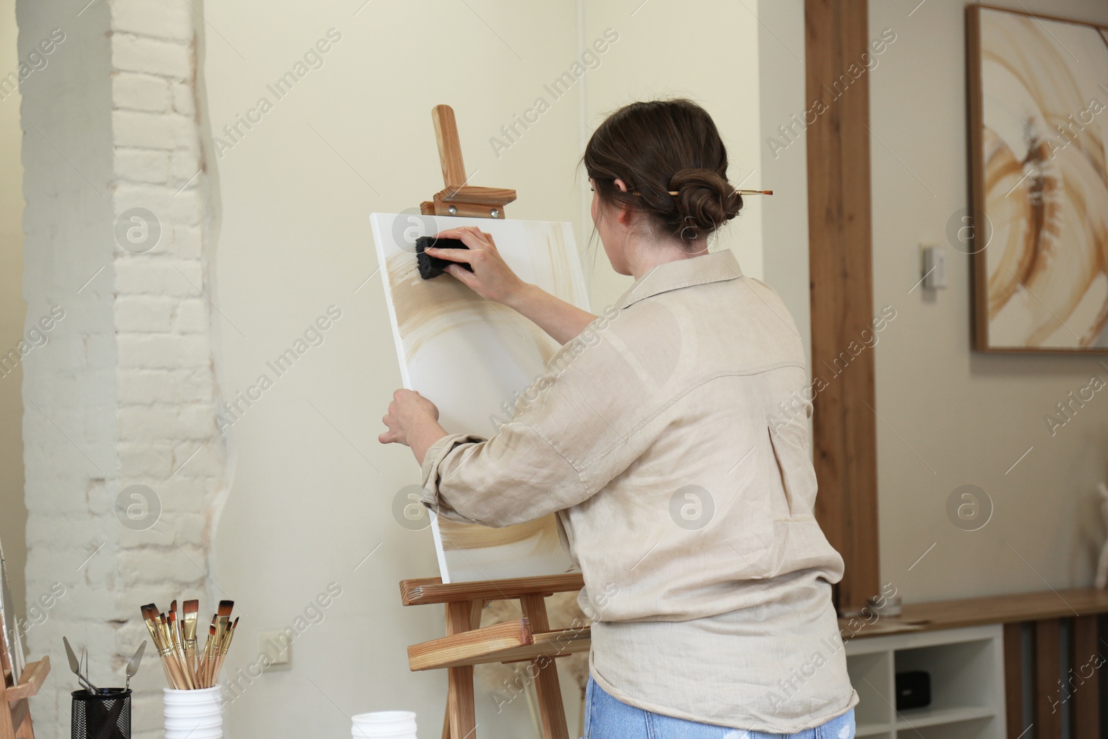 Photo of Woman creating picture with sponge in drawing studio