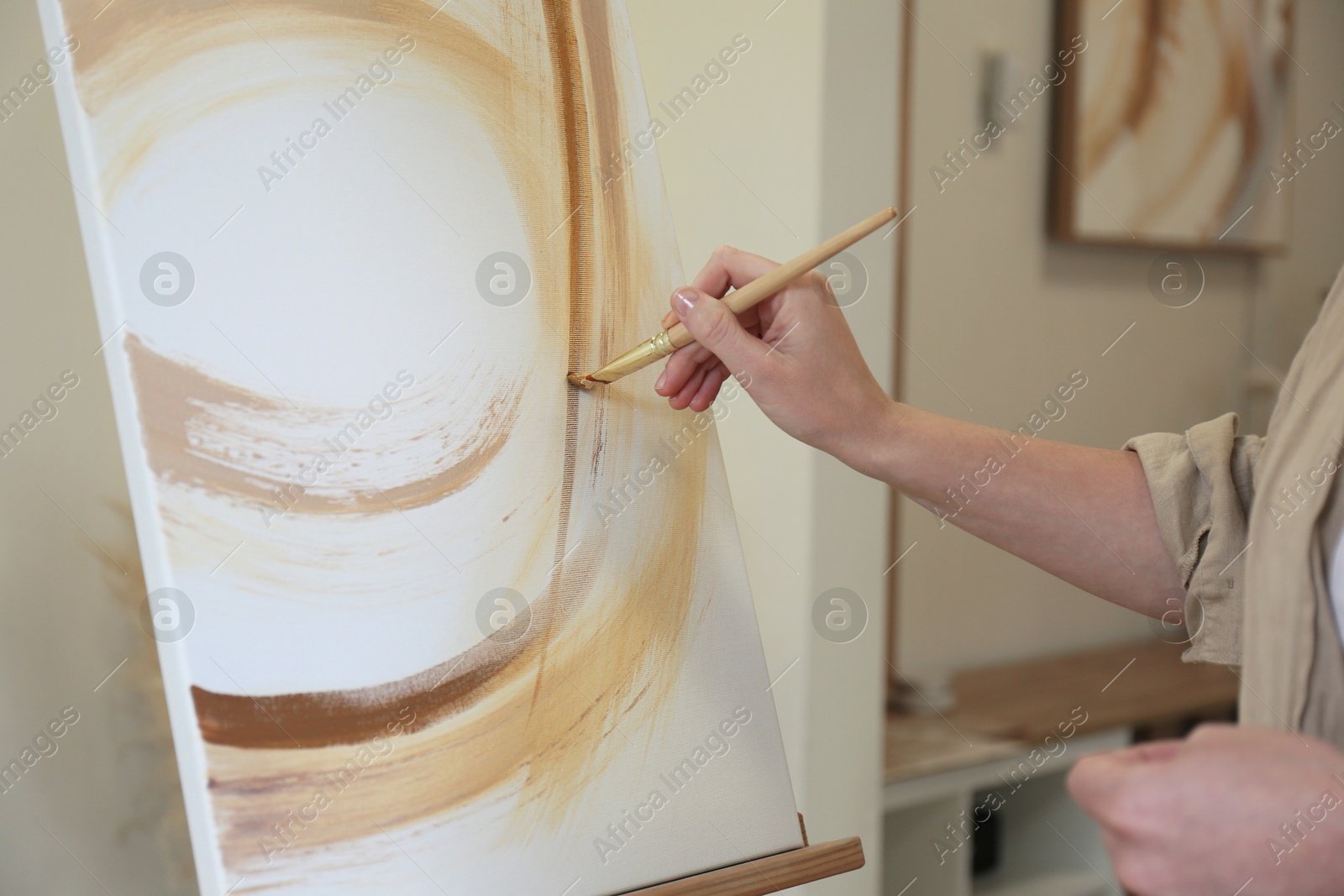 Photo of Woman drawing picture with brush in studio, closeup