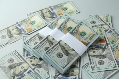 Photo of Many dollar banknotes on light background, above view