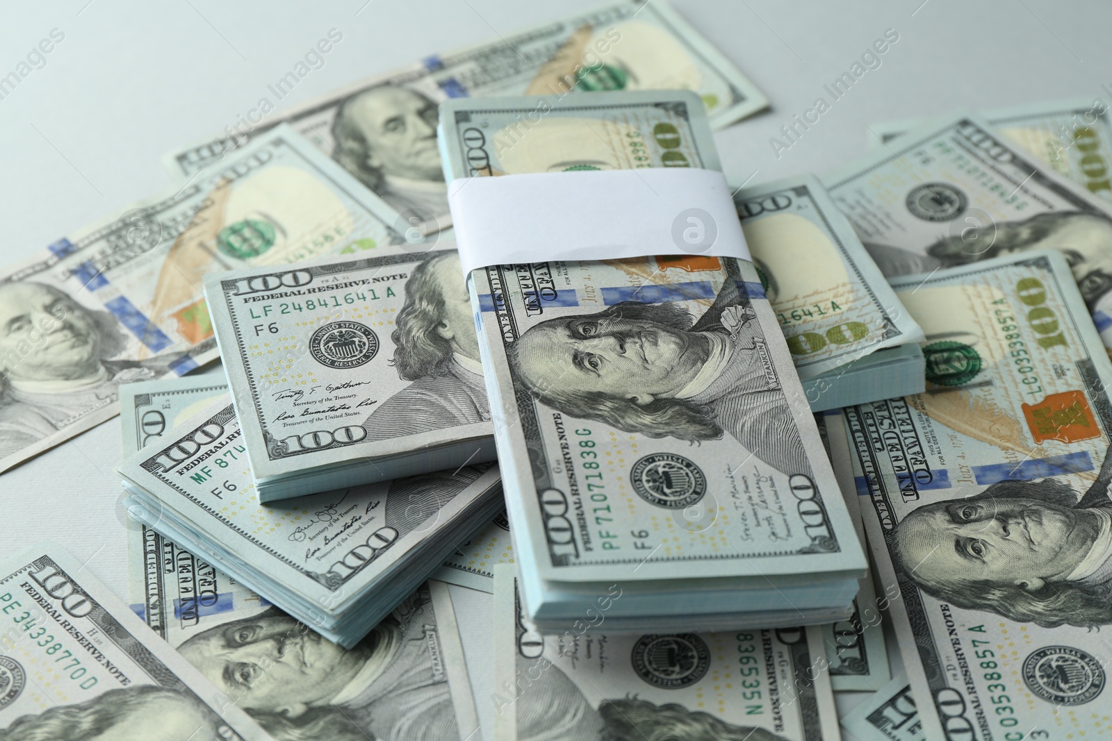 Photo of Many dollar banknotes on light background, closeup