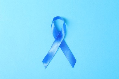 Photo of Blue ribbon on color background, top view. Prostate cancer awareness