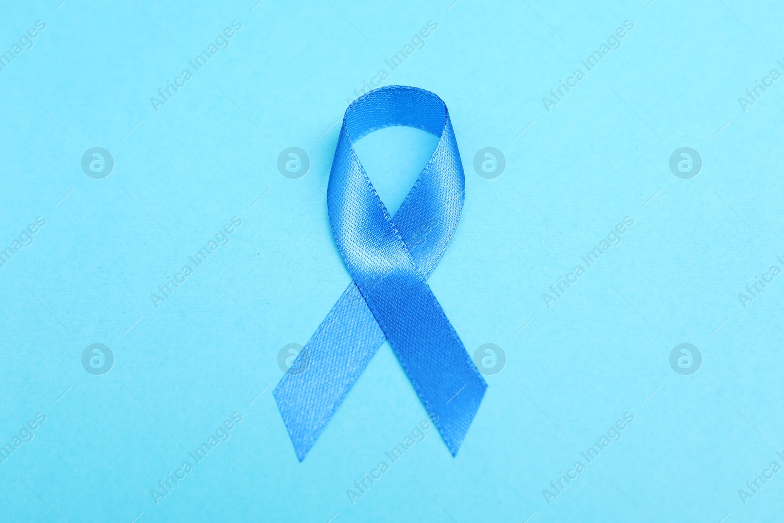 Photo of Blue ribbon on color background, top view. Prostate cancer awareness