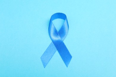 Photo of Blue ribbon on color background, top view. Prostate cancer awareness