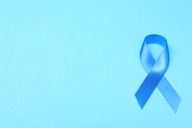 Photo of Blue ribbon on color background, top view with space for text. Prostate cancer awareness