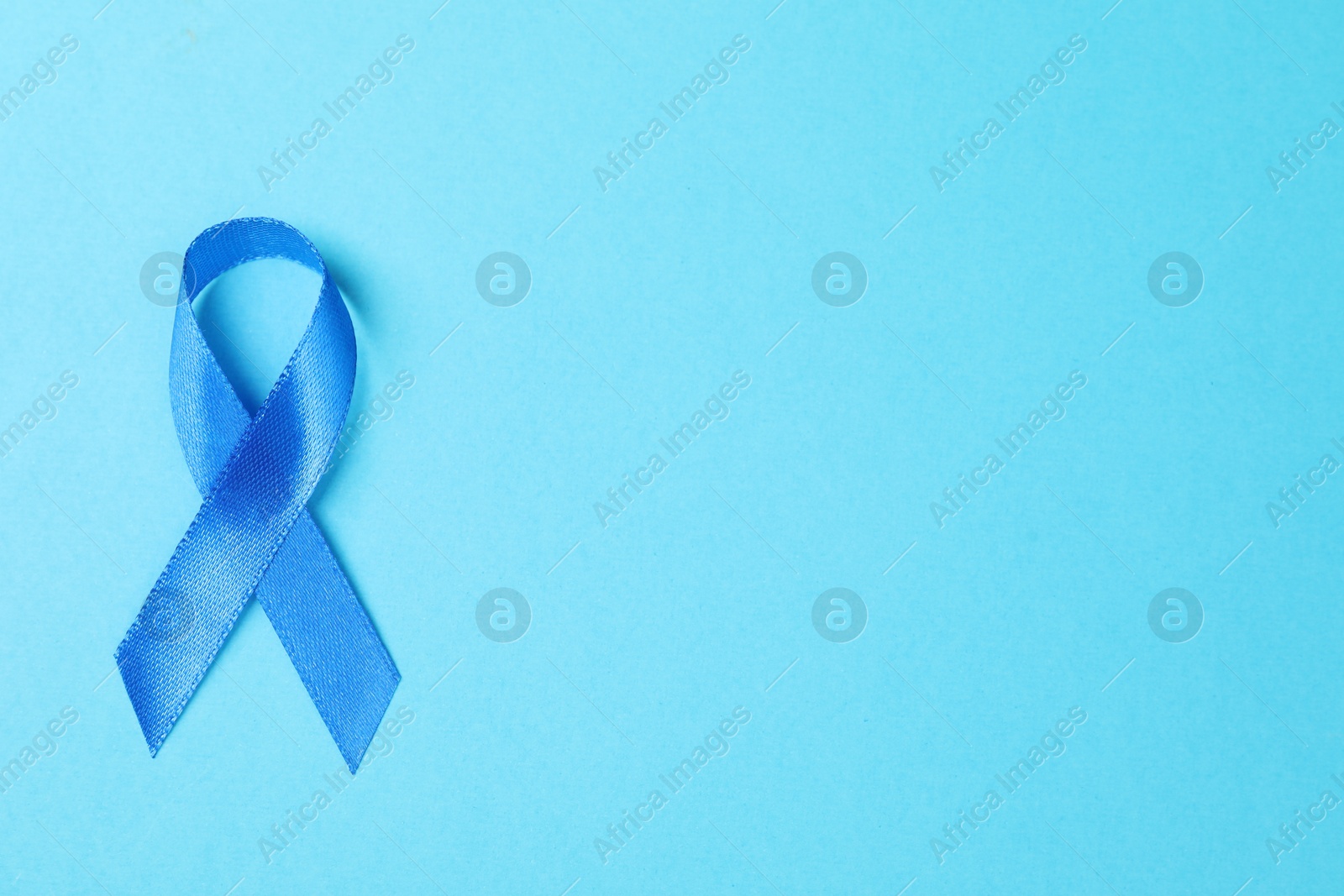 Photo of Blue ribbon on color background, top view with space for text. Prostate cancer awareness