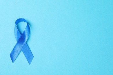 Blue ribbon on color background, top view with space for text. Prostate cancer awareness