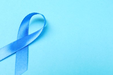 Photo of Prostate cancer awareness. Blue ribbon on color background, closeup. Space for text