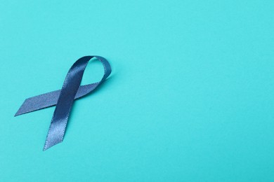 Photo of Dark blue ribbon on color background, space for text. Prostate cancer awareness