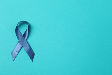Photo of Dark blue ribbon on color background, top view and space for text. Prostate cancer awareness