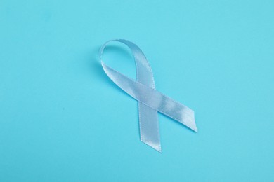 Photo of Prostate cancer awareness. Light blue ribbon on color background, space for text