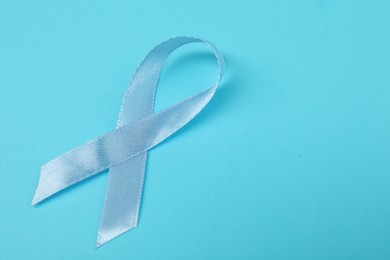 Photo of Prostate cancer awareness. Light blue ribbon on color background, closeup. Space for text