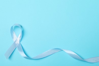 Light blue ribbon on color background, top view with space for text. Prostate cancer awareness