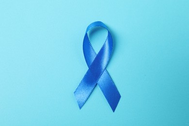 Photo of Blue ribbon on color background, top view. Prostate cancer awareness
