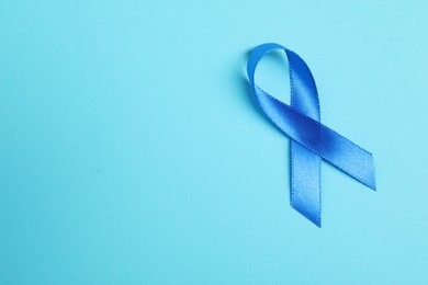 Blue ribbon on color background, top view with space for text. Prostate cancer awareness