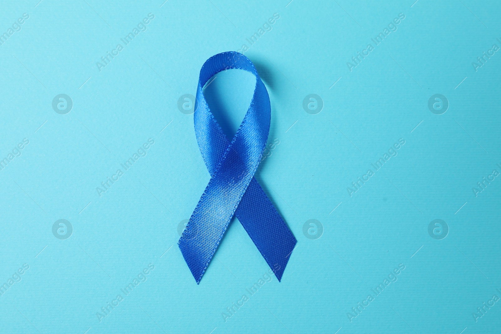 Photo of Blue ribbon on color background, top view. Prostate cancer awareness