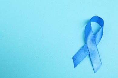 Photo of Blue ribbon on color background, top view with space for text. Prostate cancer awareness