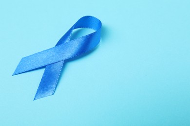 Photo of Blue ribbon on color background, space for text. Prostate cancer awareness