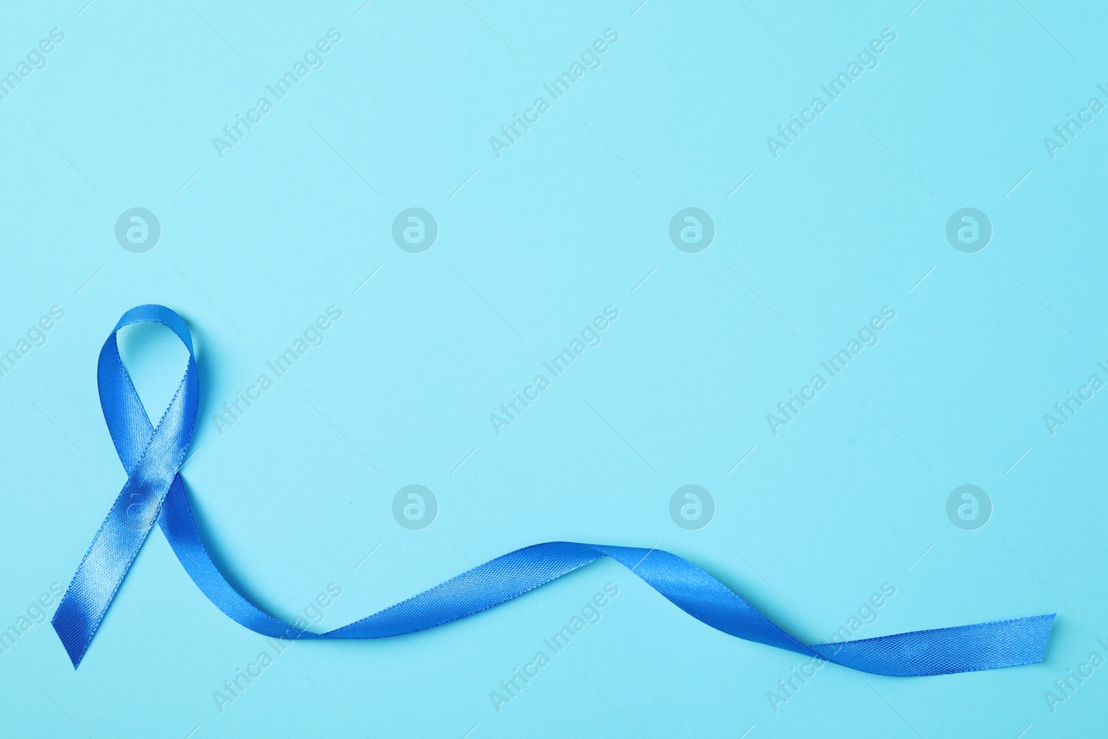 Photo of Blue ribbon on color background, top view with space for text. Prostate cancer awareness