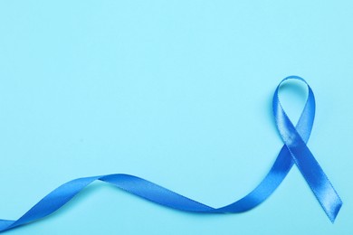 Photo of Blue ribbon on color background, top view with space for text. Prostate cancer awareness