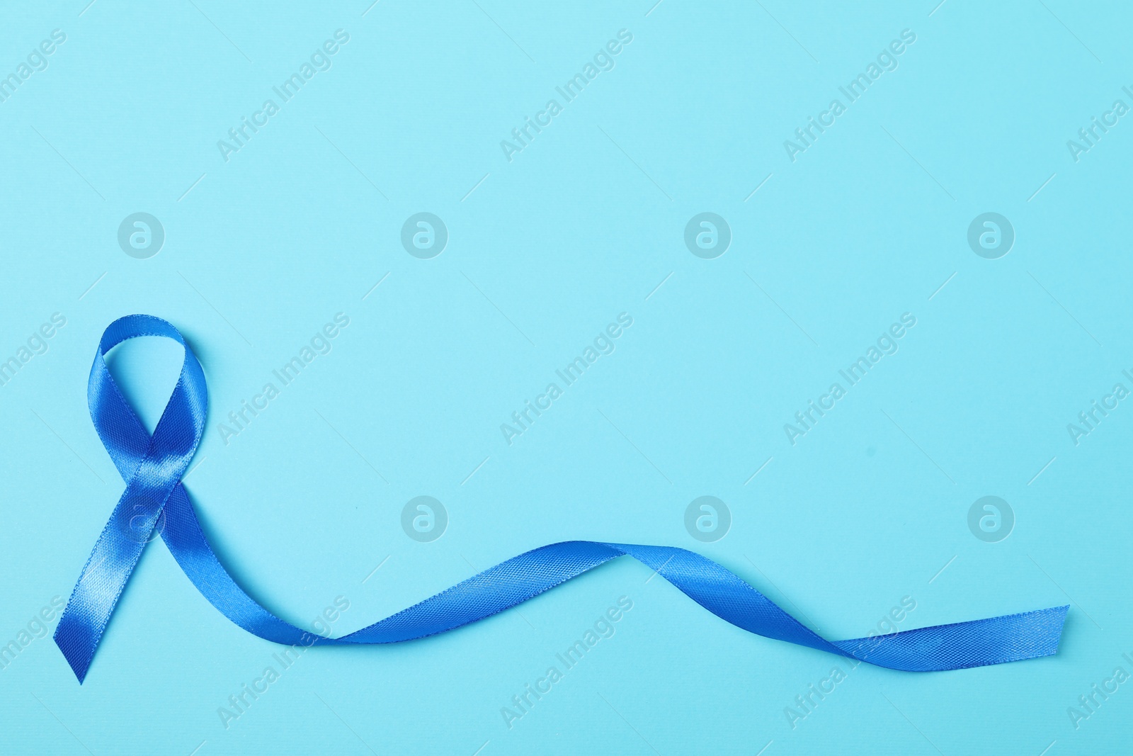 Photo of Blue ribbon on color background, top view with space for text. Prostate cancer awareness