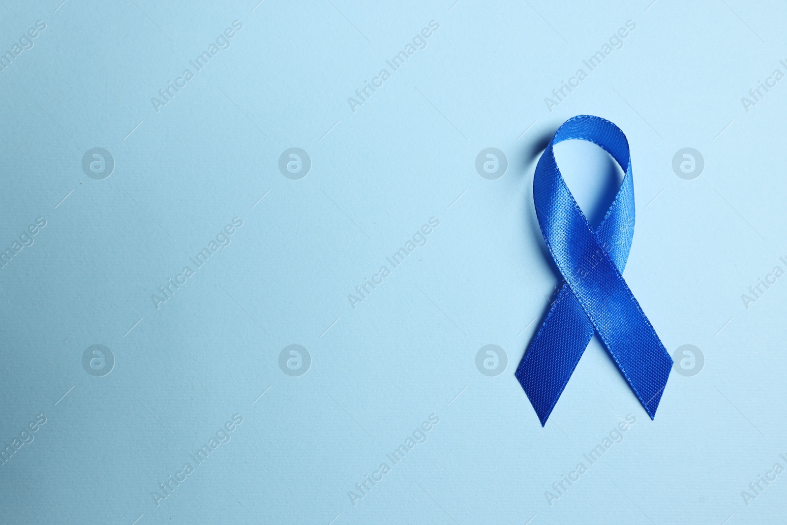 Photo of Blue ribbon on light background, top view with space for text. Prostate cancer awareness