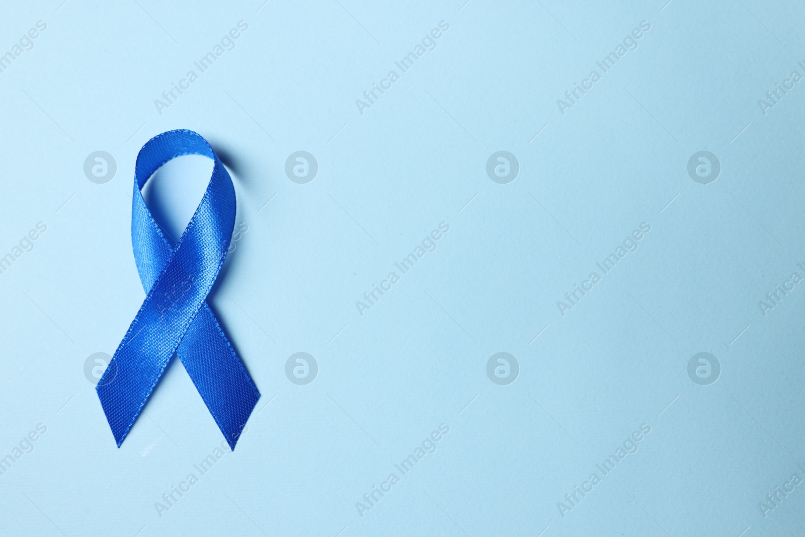 Photo of Blue ribbon on light background, top view with space for text. Prostate cancer awareness