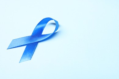 Photo of Blue ribbon on light background, space for text. Prostate cancer awareness