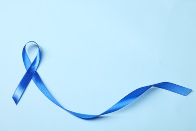 Photo of Blue ribbon on light background, top view with space for text. Prostate cancer awareness