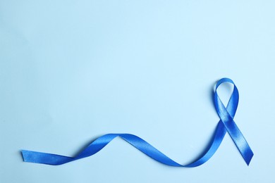 Photo of Blue ribbon on light background, top view with space for text. Prostate cancer awareness