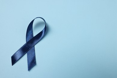 Photo of Dark blue ribbon on color background, top view with space for text. Prostate cancer awareness