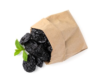 Photo of Paper bag with tasty dried plums (prunes) and mint isolated on white, top view