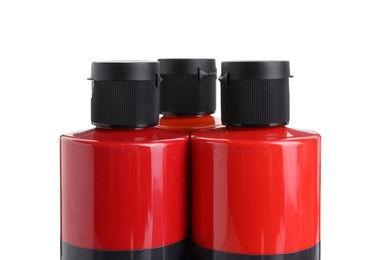 Photo of Red acrylic paints in bottles isolated on white