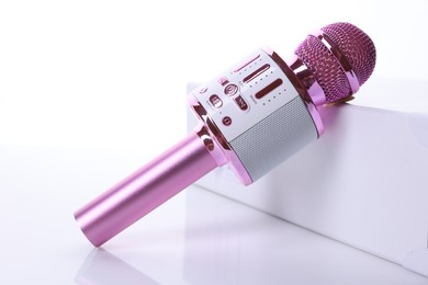 Photo of One pink karaoke microphone isolated on white