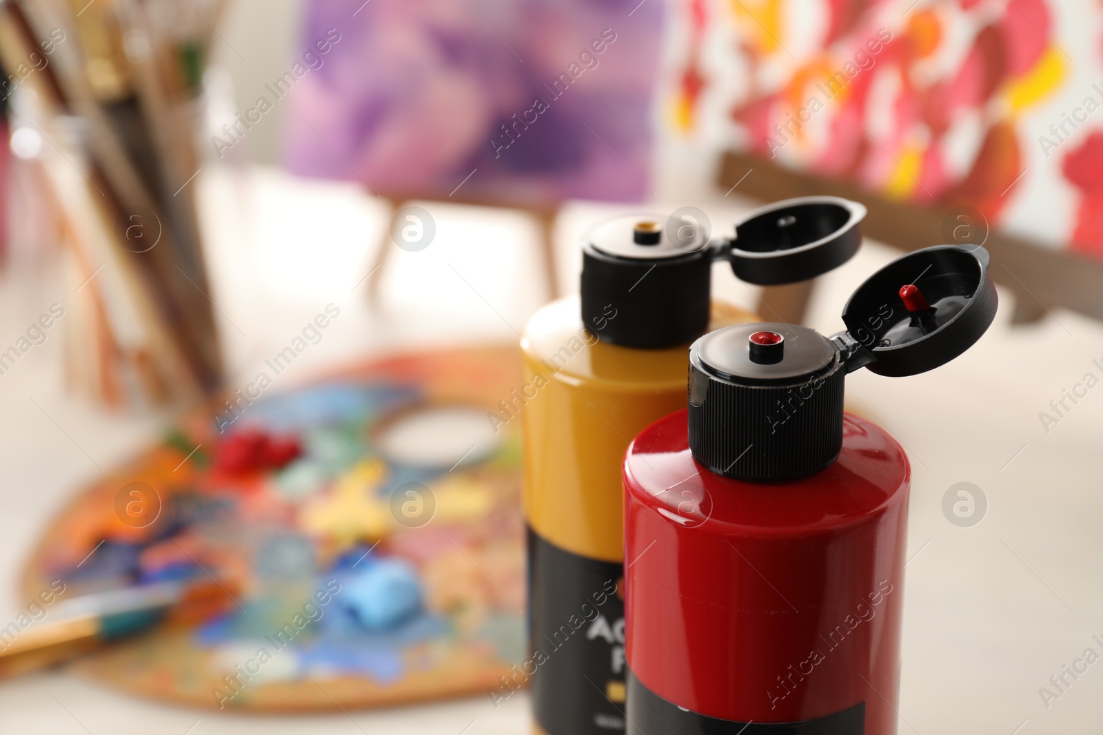 Photo of Acrylic paints of different colors on table indoors, closeup