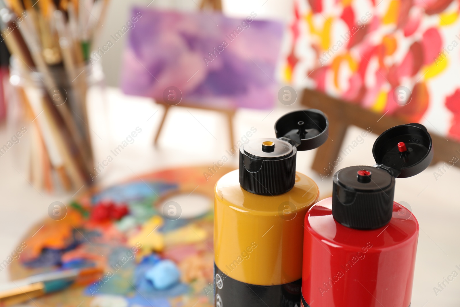 Photo of Acrylic paints of different colors on table indoors, closeup