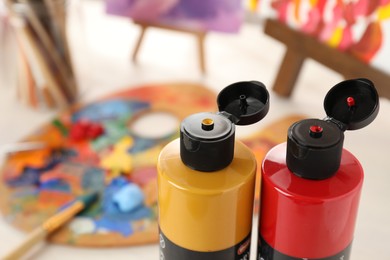 Photo of Acrylic paints of different colors on table indoors, closeup