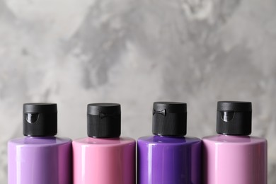 Photo of Acrylic paints of different colors against blurred background, closeup