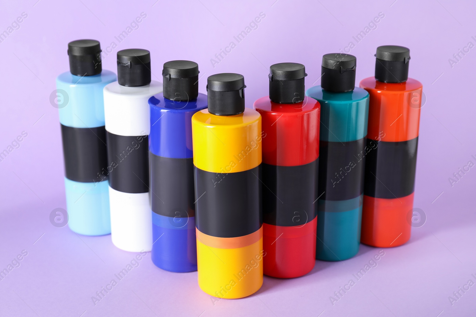 Photo of Acrylic paints of different colors on violet background